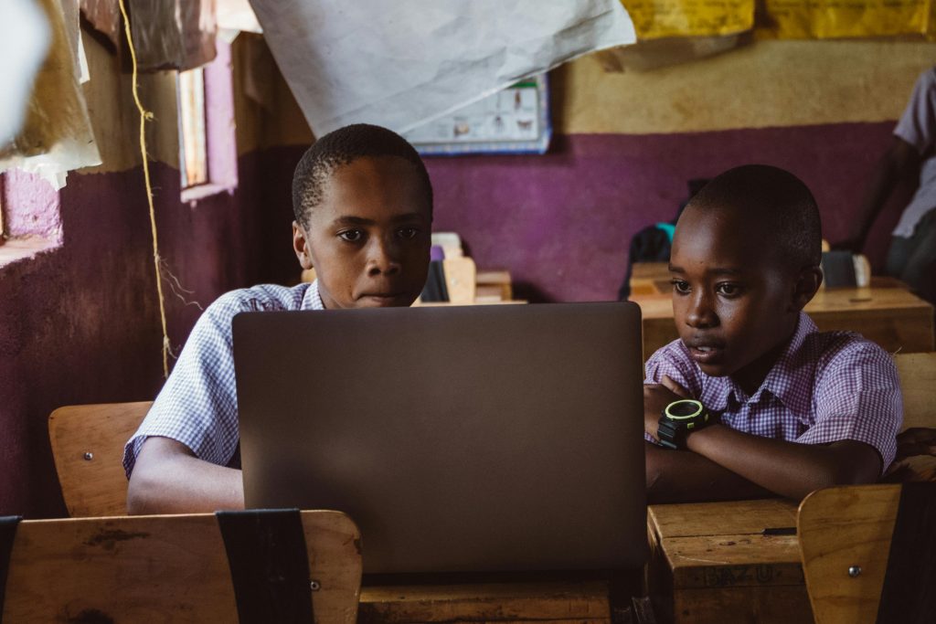 About Two boys attentively studying with a laptop in a classroom, enhancing their learning experience.