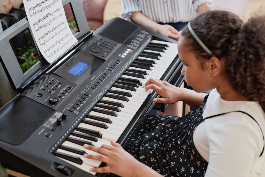 pexels photo 7714216 7714216 African American girl playing the keyboard indoors, practicing music.